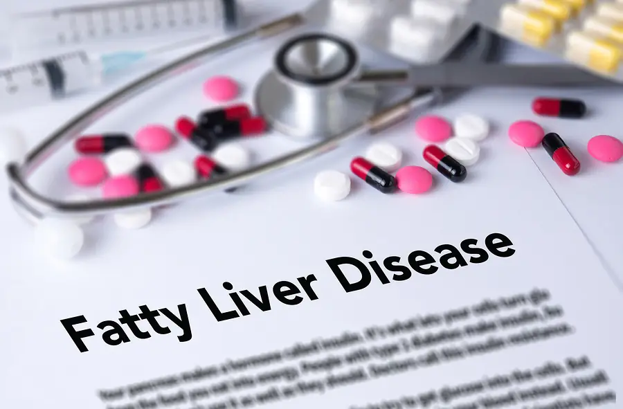 Medications and stethoscope on a document labeled Fatty Liver Disease