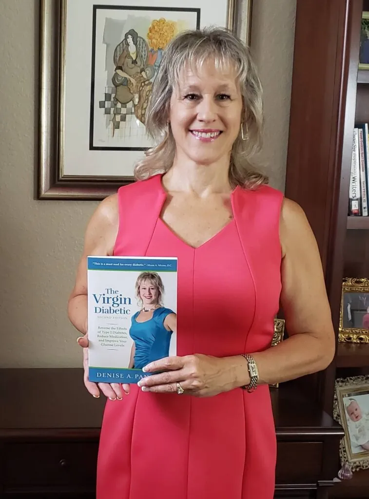 Denise Pancyrz holding a copy of her book, The Virgin Diabetic