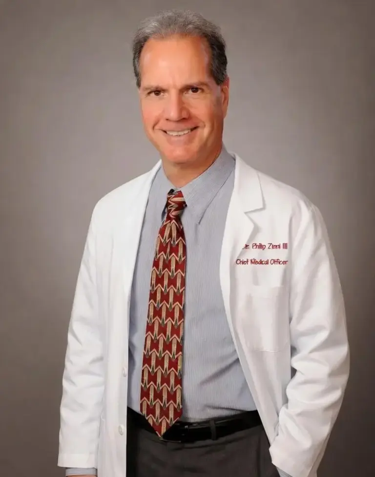 Dr. Phillip C. Zinni III standing in his white coat and tie